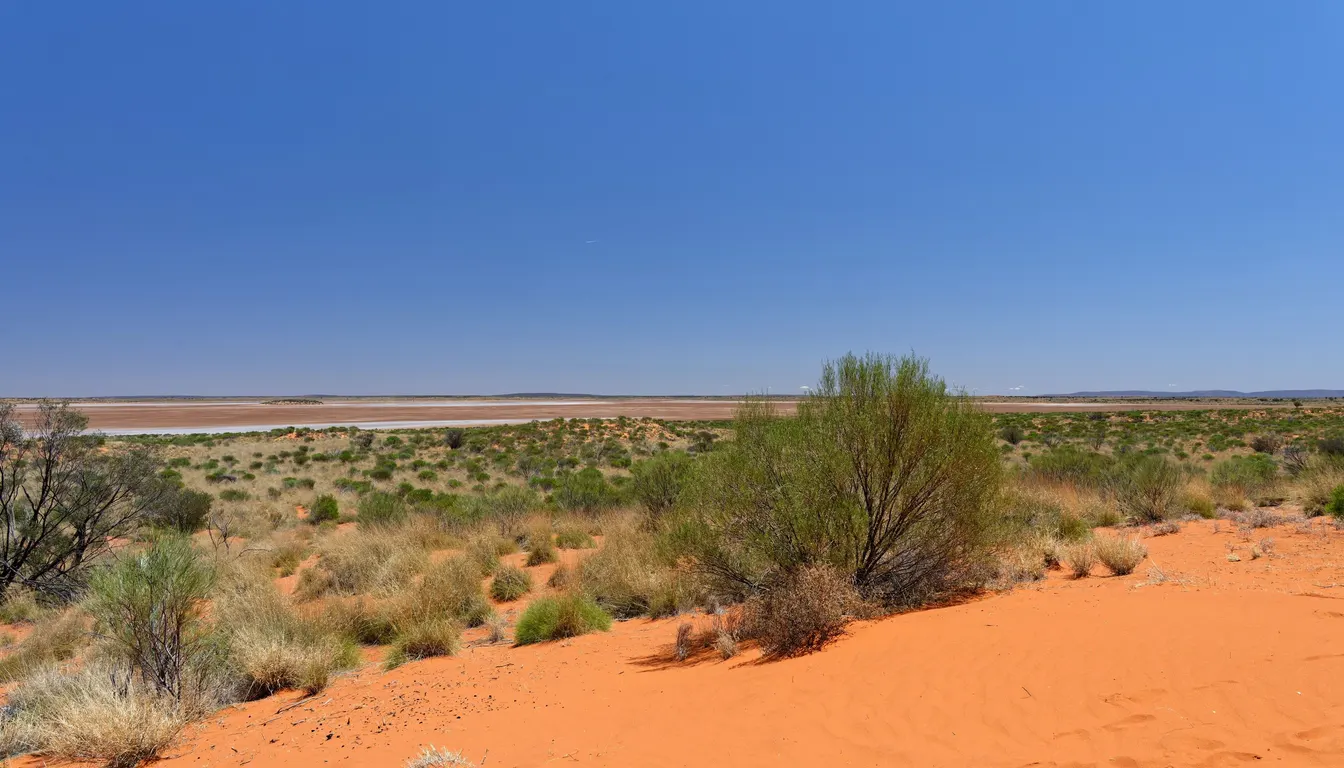 A road crossing the red Australian outback beneath a wide sky